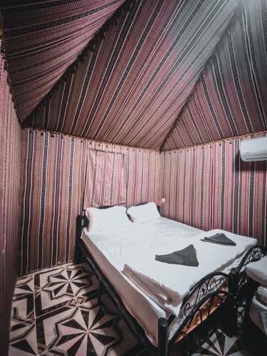 a bed in a room with a wooden ceiling at Syndebad desert camp in Wadi Rum