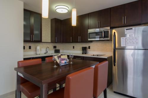 a kitchen with a wooden table and a stainless steel refrigerator at Residence Inn Raleigh-Durham Airport/Brier Creek in Raleigh