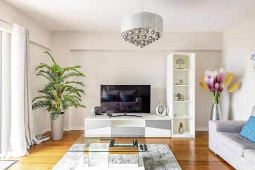 a living room with a tv and a couch at Luxury poolside view apartment in Funchal