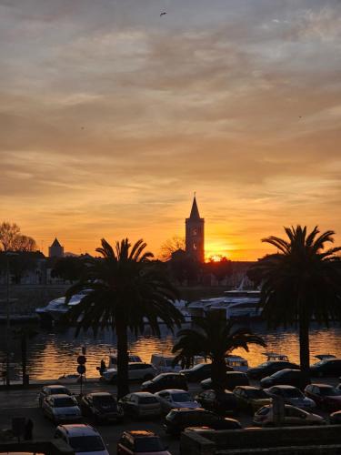 a sunset with cars parked in a parking lot with a clock tower at Apartment Mari in Zadar