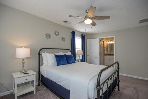 a bedroom with a bed with blue pillows and a ceiling fan at Ranch Style Home & Plenty Of BKYD Space Near KSU in Marietta