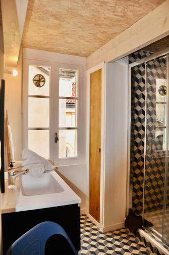 une salle de bain avec un lavabo et une fenêtre dans l'établissement les Chambres Tropéziennes, à Sanary-sur-Mer