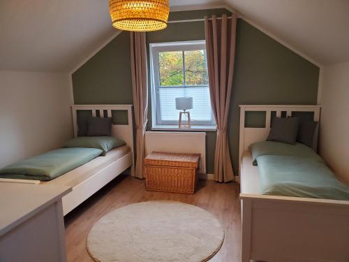 Duas camas num pequeno quarto com uma janela em Familienfreundliche Ferienwohnung Soltau em Soltau
