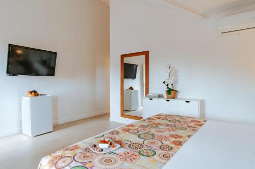 a white room with a bed with a plate of food on it at Jubarte Hotel by Insólito in Búzios