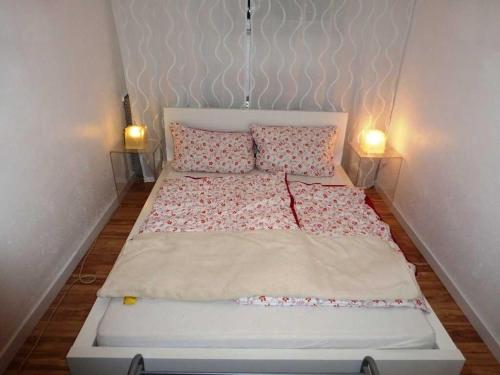 un grande letto con due cuscini e due lampade di Ferienwohnung am Wald a Erbach
