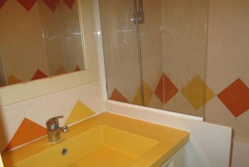 La salle de bains est pourvue d'un lavabo jaune et d'un miroir. dans l'établissement Promenade des Bains Apartment, à Saint-Raphaël