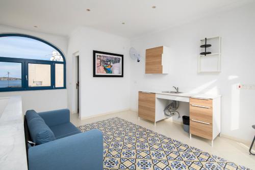 sala de estar con sofá azul y escritorio en Chic, Stylish Traditional Townhouse with Terrace - St. Paul’s Bay en St. Paul's Bay