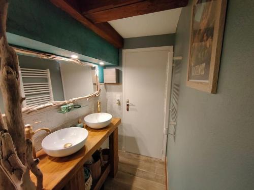 a bathroom with two sinks on a wooden counter at Le gîte '' Au fil de l'eau '' in Ria