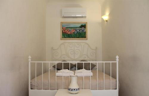 białe łóżko w sypialni z obrazem na ścianie w obiekcie Casa Naldi we Florencji