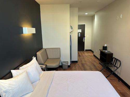 a hotel room with a bed and a chair at Feather Factory Hotel in Queens