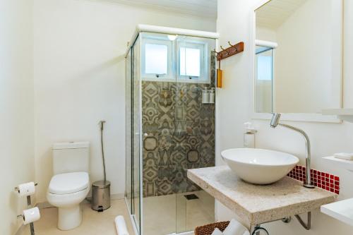a bathroom with a sink and a toilet and a shower at Jubarte Hotel by Insólito in Búzios