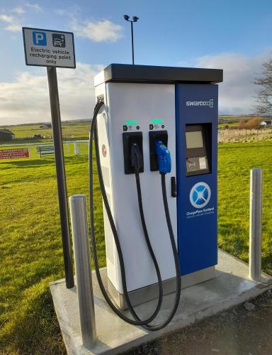 a blue and white gas pump next to a field at North Star Glamping in Lybster
