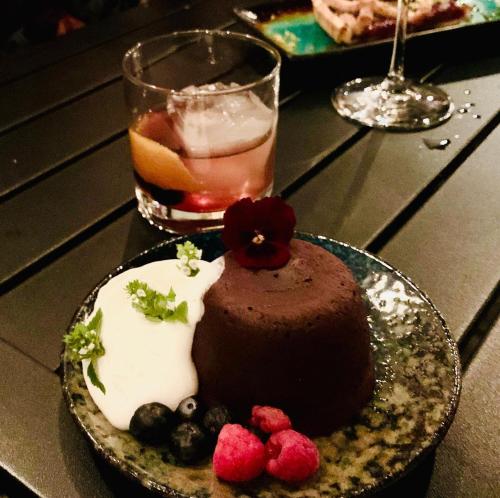 a chocolate cake and berries on a table with a drink at The Inn at 2nd & C in Eureka