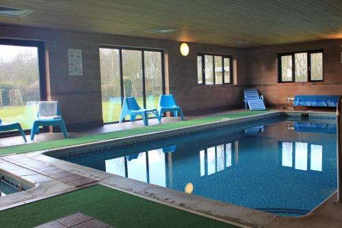a large swimming pool with blue chairs in a building at Low Costa Mill in Pickering