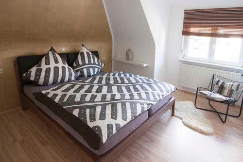 1 dormitorio con cama con almohadas y ventana en Ferienwohnung Waldblick en Bad König