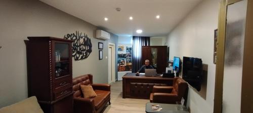 a man sitting at a desk with a computer in a room at Moab Hotel & Restaurant in Madaba