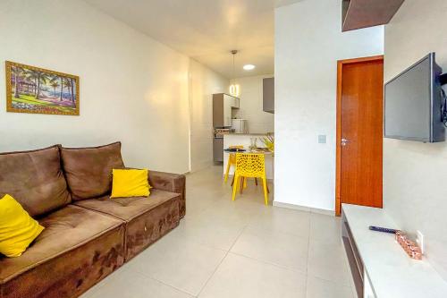 sala de estar con sofá marrón y cocina en Casa em frente ao mar c lazer em Barra de São João, en Casimiro de Abreu