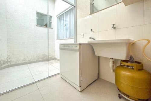 a bathroom with a sink and a washing machine at Casa c piscina em frente ao mar-Barra de Sao Joao in Casimiro de Abreu