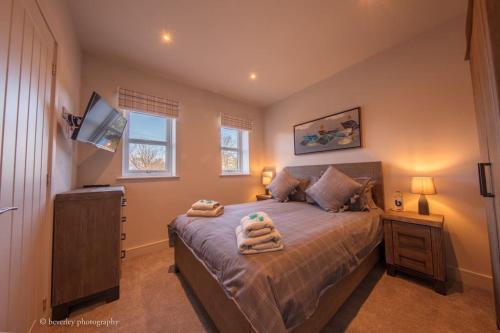 a bedroom with a bed with two towels on it at Molehill Cottage - New 2023 - EV Charger - Pets in Beverley
