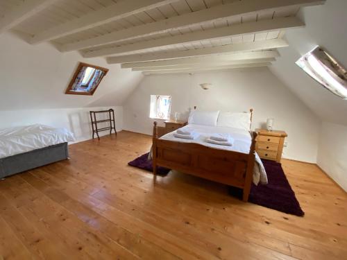 a bedroom with a bed and a wooden floor at Traditional 18th Century Welsh Cottage in Llandovery