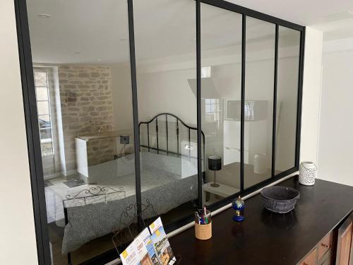 a room with a glass wall with a bed in it at Le Saint-Hilaire in Saint-Hilaire-de-Brens