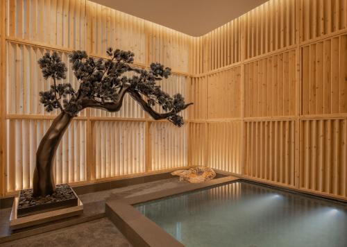 a room with a bonsai tree and a pool at Le Meridien Bangkok in Bangkok