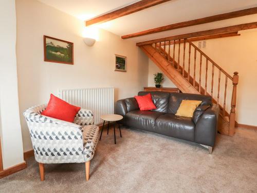 a living room with a leather couch and a table at Rivendell in Holmfirth