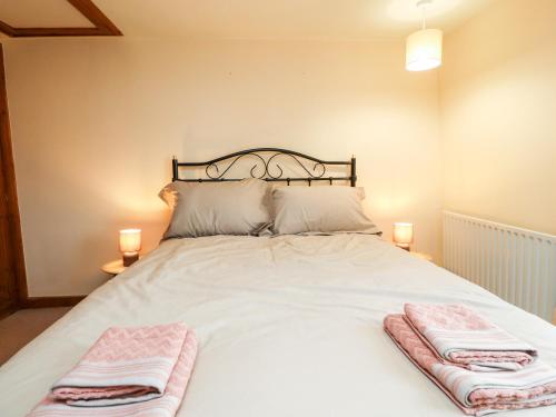 a bedroom with a white bed with two towels on it at Rivendell in Holmfirth