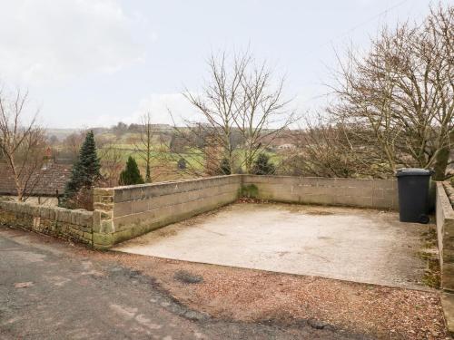 a large concrete patio with a retaining wall at Rivendell in Holmfirth