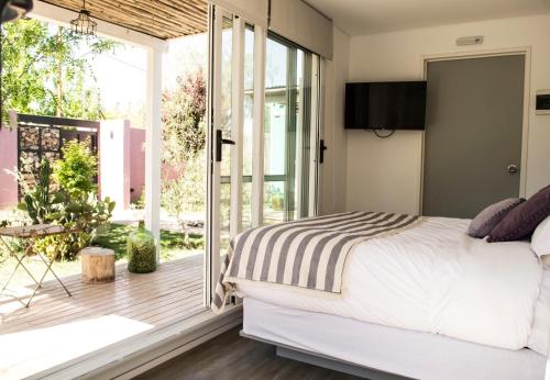 a bedroom with a bed and a large window at Refugio Padma in Chacras de Coria