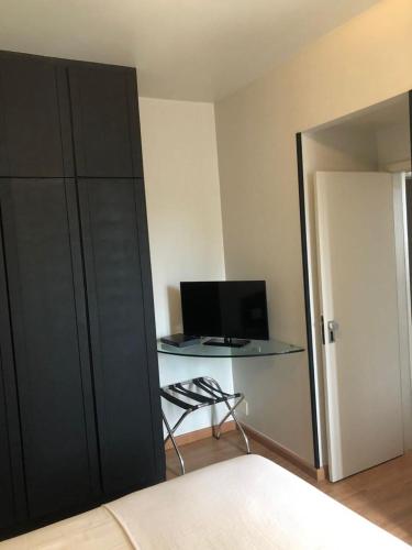 a bedroom with a bed and a desk with a computer at Max Savassi Glamour in Belo Horizonte