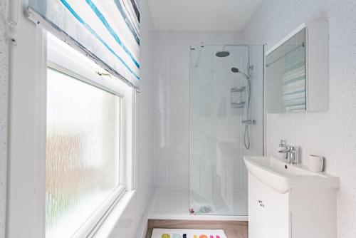 a white bathroom with a shower and a sink at Southbeach by Bloom Stays in Hythe