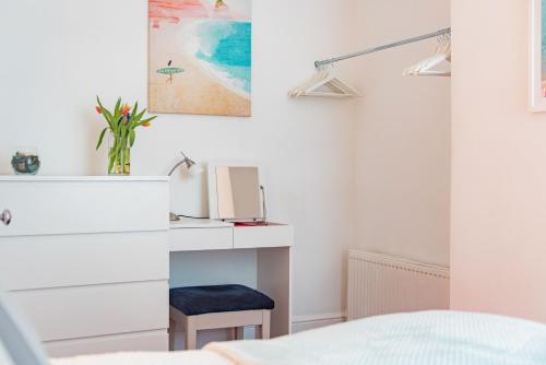 a bedroom with a white dresser and a blue stool at Southbeach by Bloom Stays in Hythe