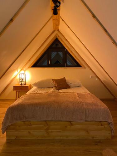 Un dormitorio con una cama grande en un ático. en Stodoła na polanie, en Poronin