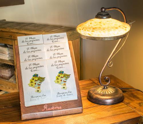 a sign on a table next to a lamp at Hostal Rural Txapi Txuri Logis Hotels in Murillo el Fruto