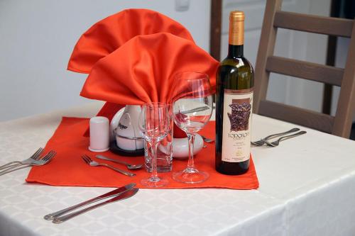 a bottle of wine and two glasses on a table at Арт комплекс Горски дом - Трявна in Tryavna