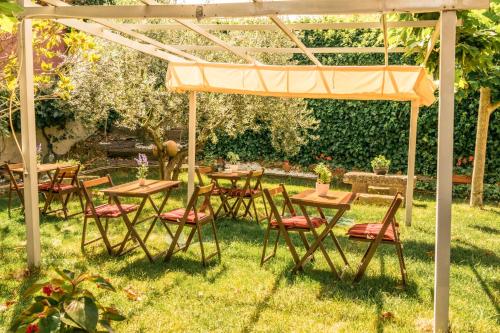 a group of tables and chairs under a pergola at Hostal Rural Txapi Txuri Logis Hotels in Murillo el Fruto