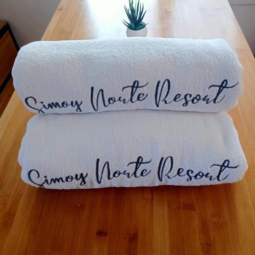two towels sitting on top of a wooden table at SimoyNorte Private Resort Beneg, Botolan, Zambales, Philippines in Zambales