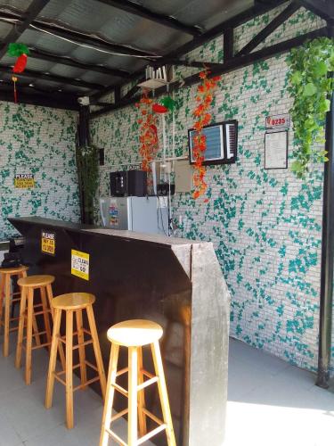 a bar with stools in front of a wall at SimoyNorte Private Resort Beneg, Botolan, Zambales, Philippines in Zambales