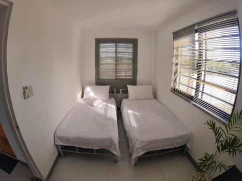two beds in a small room with a window at SimoyNorte Private Resort Beneg, Botolan, Zambales, Philippines in Zambales