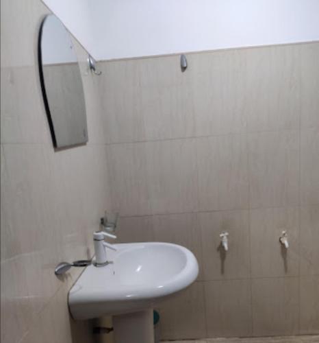 W łazience znajduje się biała umywalka i lustro. w obiekcie Sun & Sand Guest House w mieście Mullaittivu