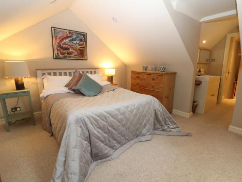 1 dormitorio con 1 cama y lavamanos en el ático en Pudding Hill Barn Cottage, en Cirencester