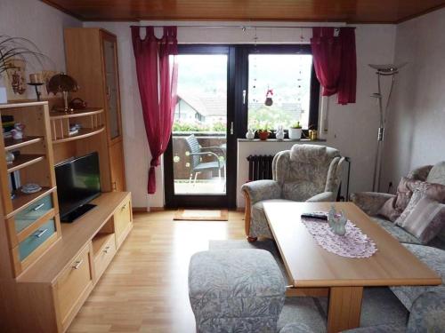 a living room with a couch and a table and a tv at Ferienwohnung Kraemer in Erbach in Erbach im Odenwald