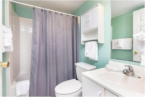 Un baño con inodoro, lavabo y ducha. en Royal Palms Unit 906, en Gulf Shores