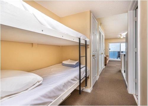 Una habitación con dos literas y un pasillo. en Royal Palms Unit 906, en Gulf Shores