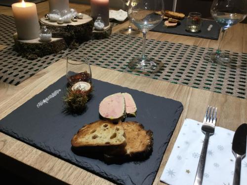 cabane lodge avec spa privatif في Livernon: طاولة مقدمة مع شريحة من الخبز واكواب من النبيذ