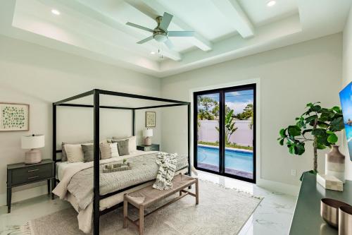 a bedroom with a bed and a ceiling fan at Brand New Luxury Naples 4br W Pool By Vanderbilt Beach Coastal Sol By Boutiq in Naples