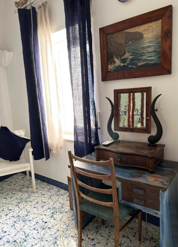 a desk with a chair and a picture on the wall at Capri magic house on the beach in Capri