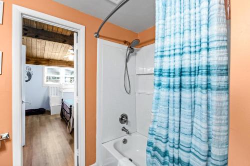 uma casa de banho com uma cortina de chuveiro azul e uma banheira em Carolina Coasting em Atlantic Beach