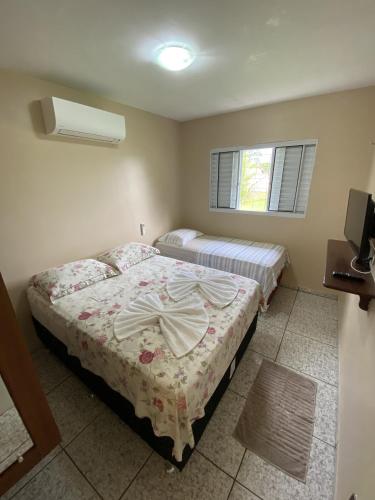 a bedroom with two beds and a window at Casa Bouganville in Novo Airão
